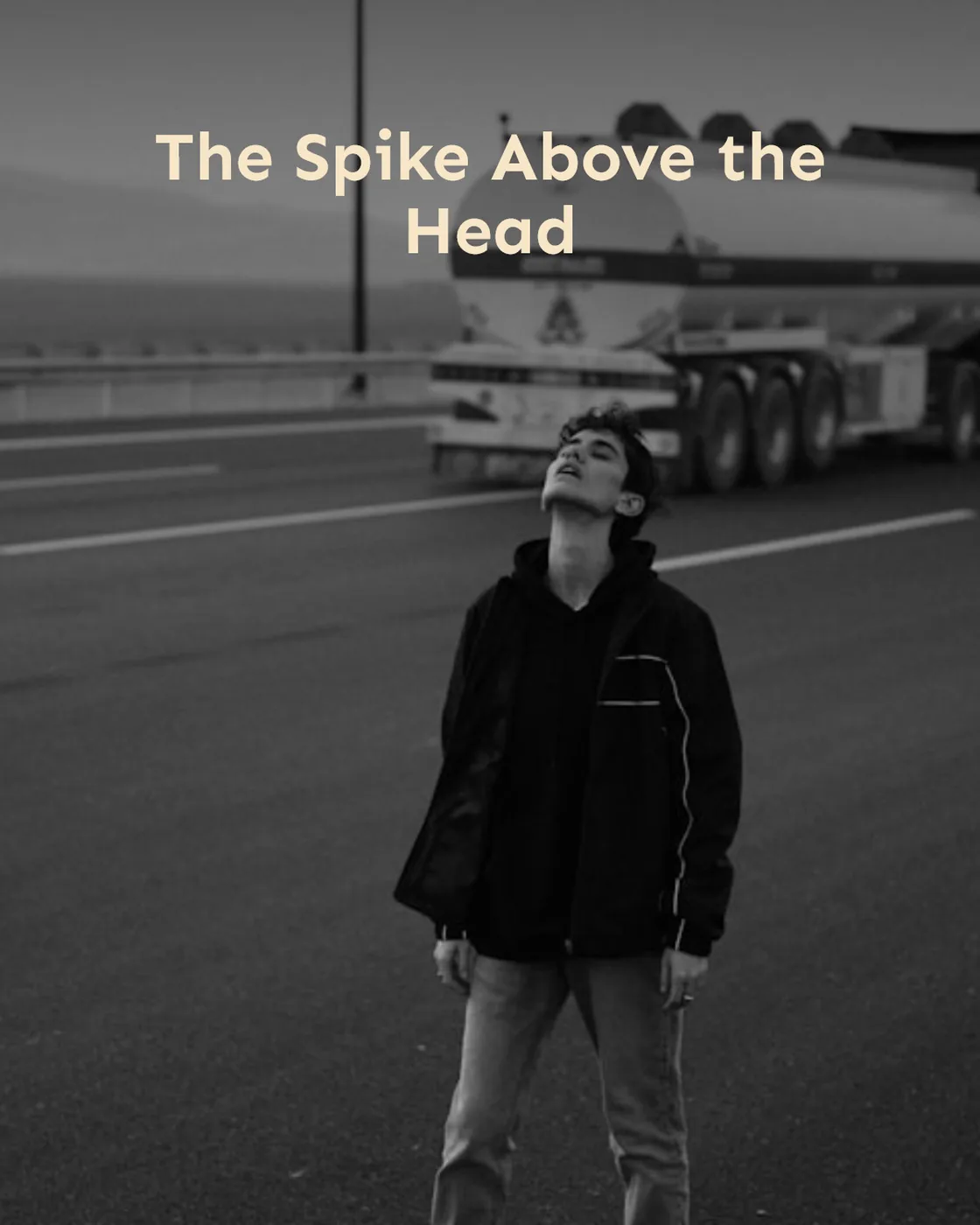 Man looking up on highway with tanker truck.