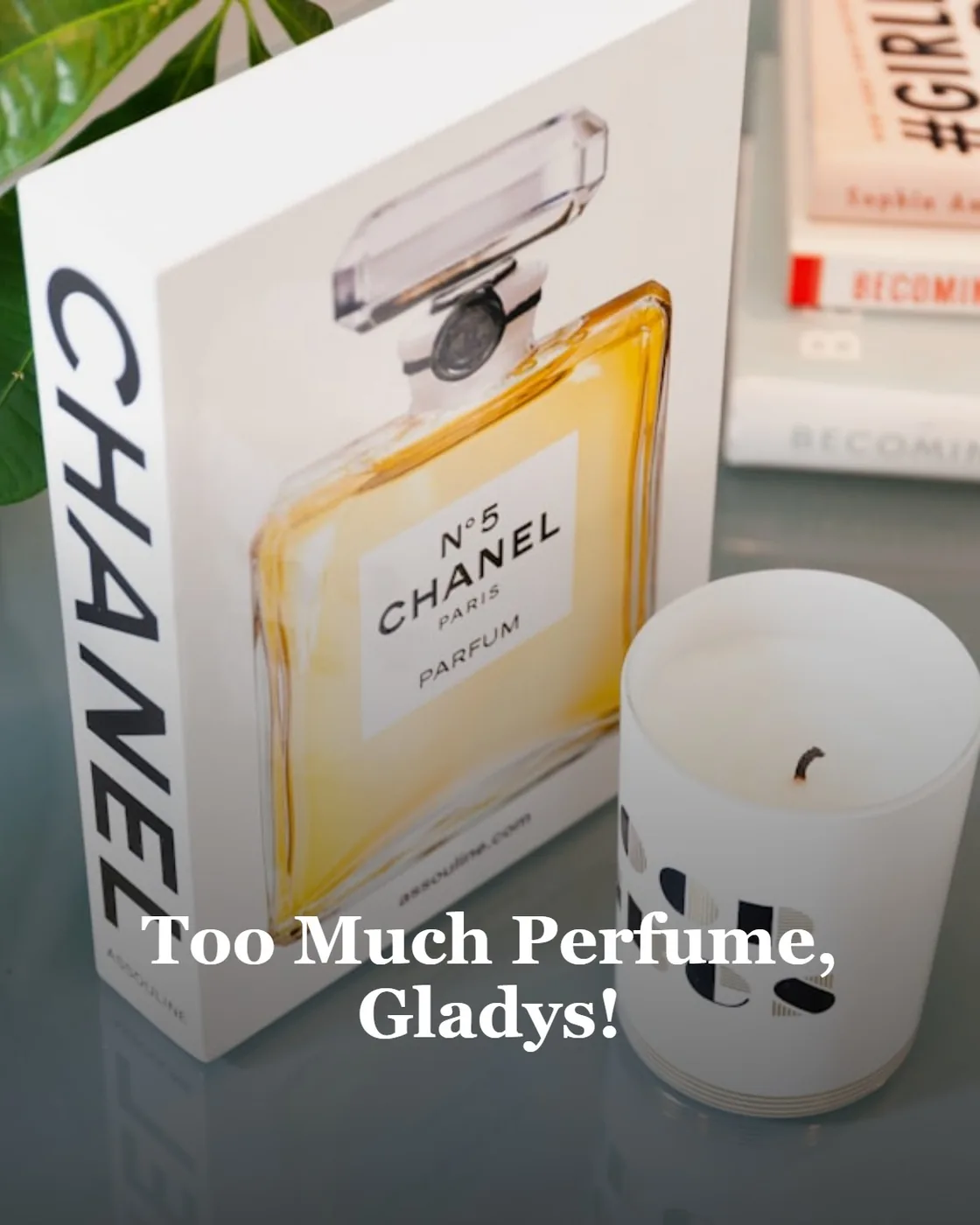 a box of perfume next to a candle on a table